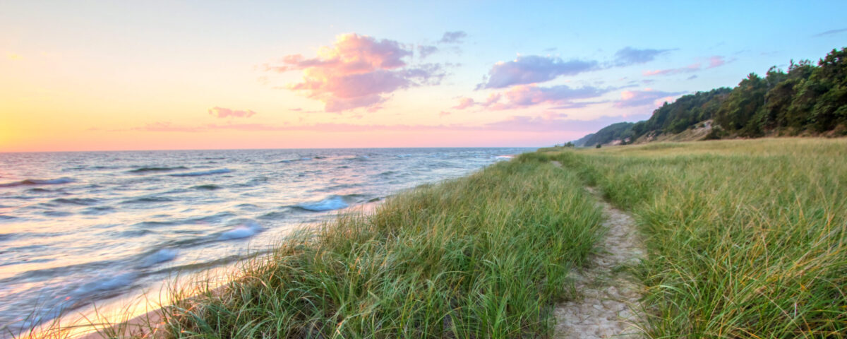 A Walk On The Beach Sandy trail winds along a Great Lakes beach with a sunset horizon and sand dunes as a backdrop Muskegon Michigan