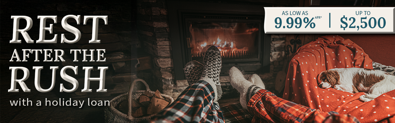 A dog laying on a chair next to two people with their socked feet warming next to a fire place. Text says Rest after the Rush with a holiday loan"