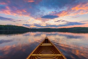 Bow of cedar canoe on a lake at sunset